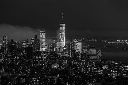 New York City skyline with lower Manhattan skyscrapers in storm at night. Black and white image.