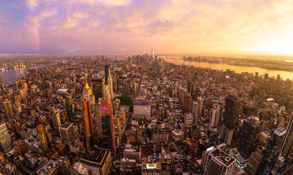 New York City skyline with Manhattan skyscrapers at dramatic vibrant after the storm sunset, USA. Rainbow can be seen in background over Brooklyn bridge.