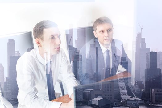 Image of two thoughtful businessmen looking at data on computer screens at business meeting in moder office against new york city manhattan buildings and skyscrapers window reflection.