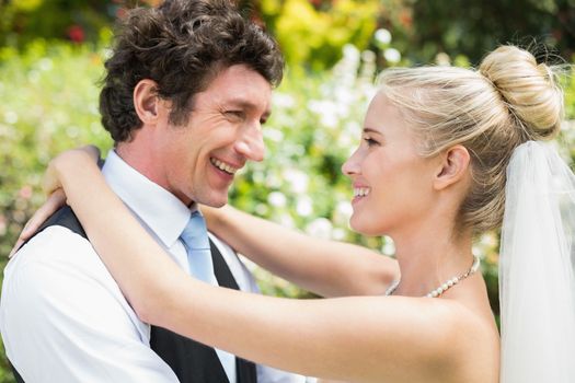 Romantic happy newlywed couple hugging each other in the countryside