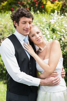 Romantic happy newlywed couple embracing each other in the countryside