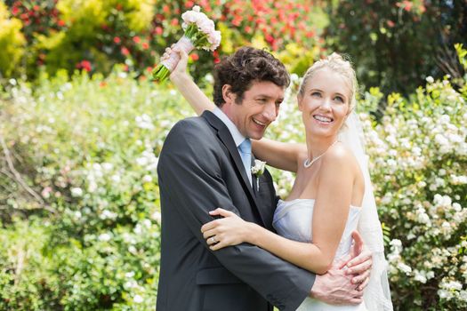 Romantic happy newlyweds hugging each other in the countryside