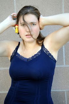 Female beauty fashion model expressions against a wall outside.