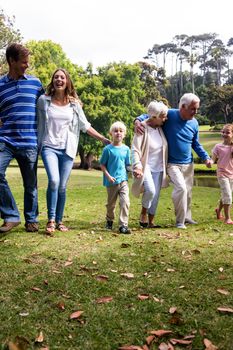 Multi-generation family walking together in the park on a sunny day