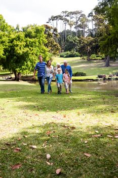 Multi-generation family walking together in the park on a sunny day