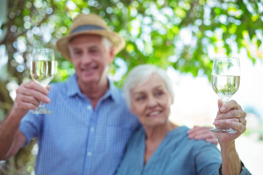 Couple holding white wine while standing outdoors
