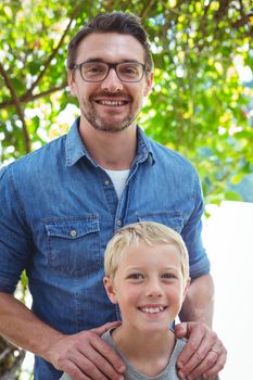 Portrait of smiling father and son standing outdoors