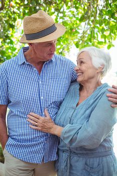 Smiling senior couple with arm around while talking outdoors