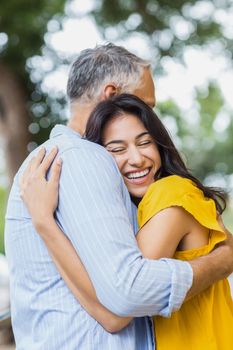 Happy woman hugging man while standing outdoors