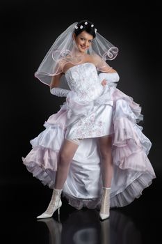 Young beautiful woman in a wedding dress on a studio background