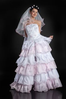 Young beautiful woman in a wedding dress on a studio background