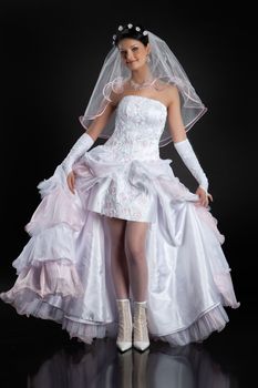 Young beautiful woman in a wedding dress on a studio background
