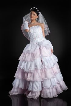 Young beautiful woman in a wedding dress on a studio background
