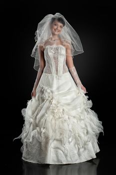 Young beautiful woman in a wedding dress on a studio background
