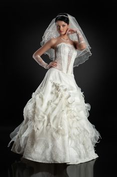 Young beautiful woman in a wedding dress on a studio background