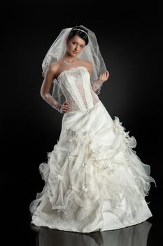 Young beautiful woman in a wedding dress on a studio background