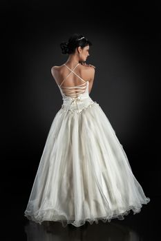Young beautiful woman in a wedding dress on a studio background