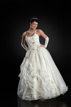 Young beautiful woman in a wedding dress on a studio background
