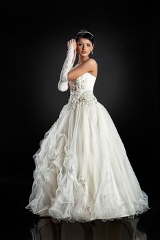Young beautiful woman in a wedding dress on a studio background