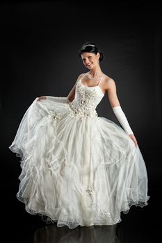 Young beautiful woman in a wedding dress on a studio background