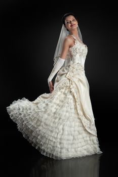 Young beautiful woman in a wedding dress on a studio background