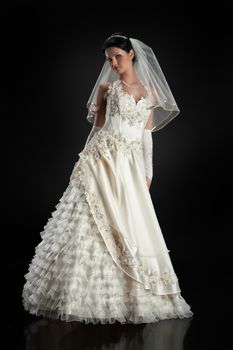 Young beautiful woman in a wedding dress on a studio background