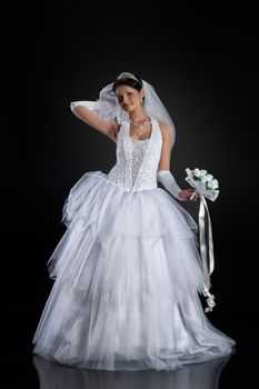 Young beautiful woman in a wedding dress on a studio background