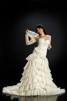 Young beautiful woman in a wedding dress on a studio background
