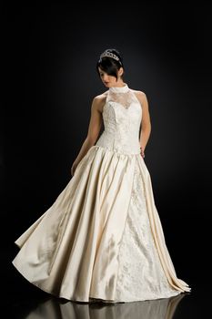 Young beautiful woman in a wedding dress on a studio background