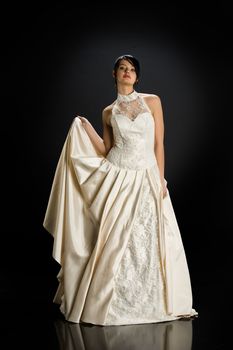 Young beautiful woman in a wedding dress on a studio background