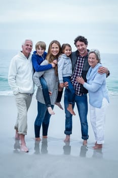 Portrait of cheerful multi-generation family standing at sea shore