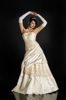Young beautiful woman in a wedding dress on a studio background