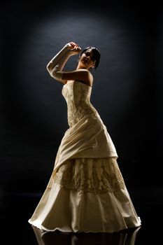 Young beautiful woman in a wedding dress on a studio background