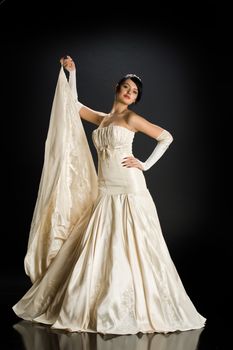 Young beautiful woman in a wedding dress on a studio background
