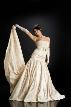 Young beautiful woman in a wedding dress on a studio background