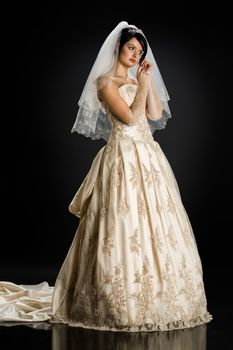 Young beautiful woman in a wedding dress on a studio background