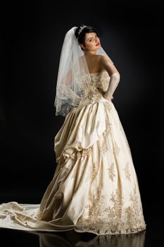 Young beautiful woman in a wedding dress on a studio background