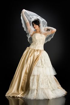 Young beautiful woman in a wedding dress on a studio background