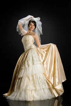 Young beautiful woman in a wedding dress on a studio background