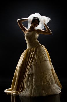 Young beautiful woman in a wedding dress on a studio background