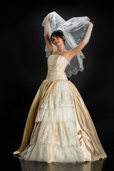 Young beautiful woman in a wedding dress on a studio background