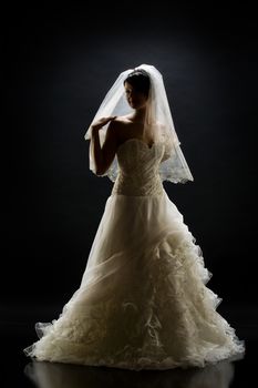 Young beautiful woman in a wedding dress on a studio background