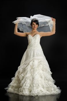 Young beautiful woman in a wedding dress on a studio background