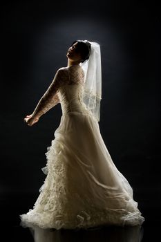 Young beautiful woman in a wedding dress on a studio background