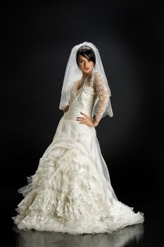 Young beautiful woman in a wedding dress on a studio background