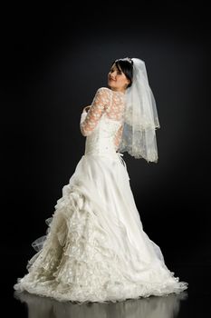 Young beautiful woman in a wedding dress on a studio background