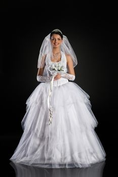 Young beautiful woman in a wedding dress on a studio background