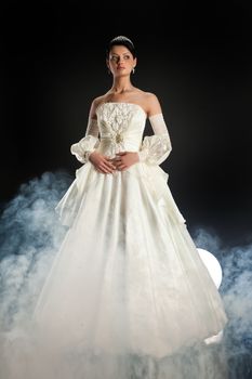 Young beautiful woman in a wedding dress on a studio background