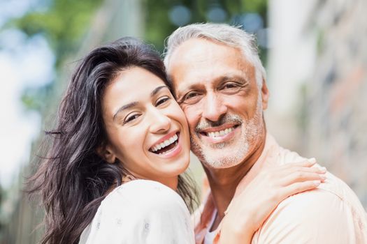 Close-up portrait of happy couple embracing outdoors