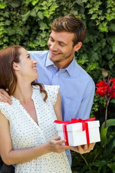 Romantic man giving gift to woman at front yard